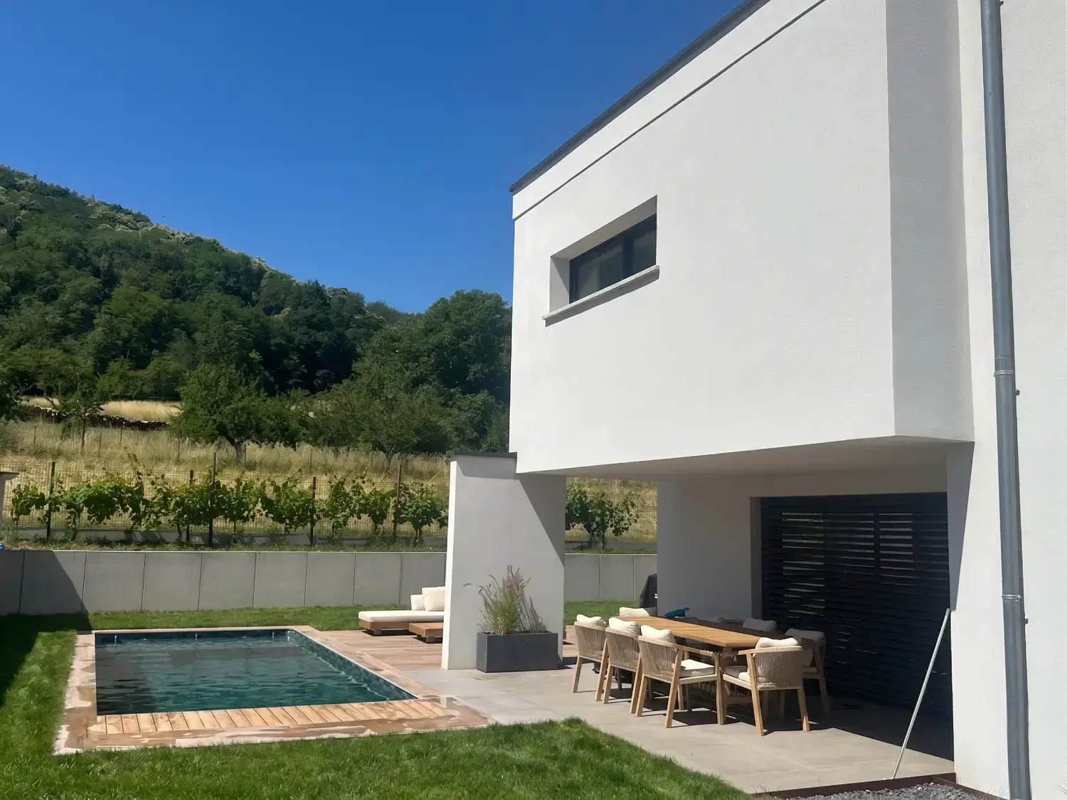 Piscine en béton intégrée à un jardin paysagé