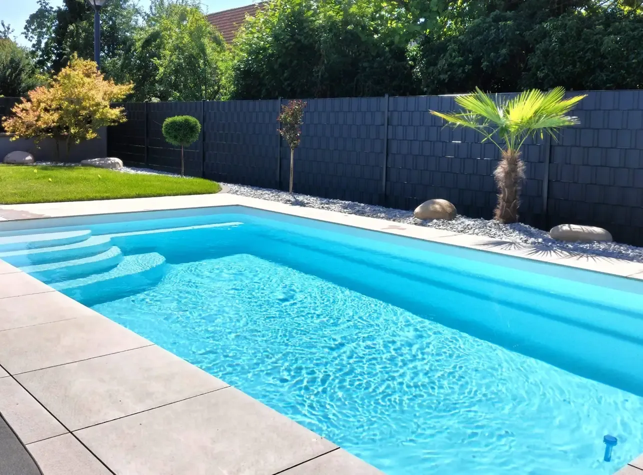Piscine coque enterrée, modèle KAREN, avec margelles en pierre.
