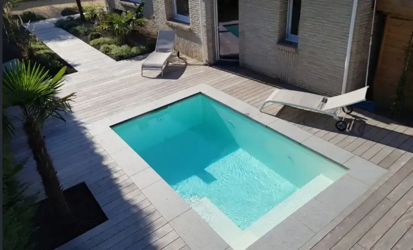 Piscine coque modèle NOIZE avec terrasse en bois.